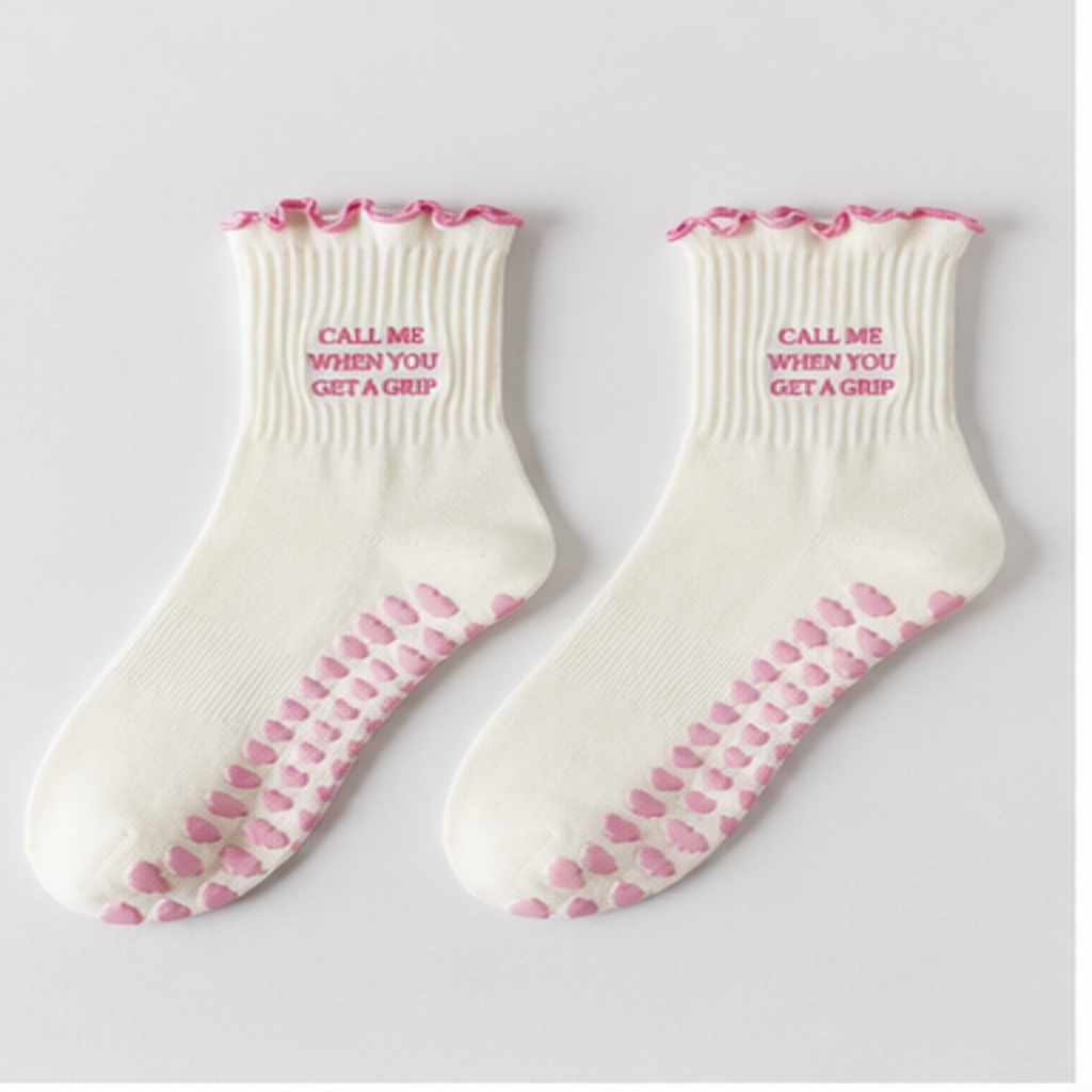 Pair of cream Pilates grip socks with pink ruffled cuffs and pink grips